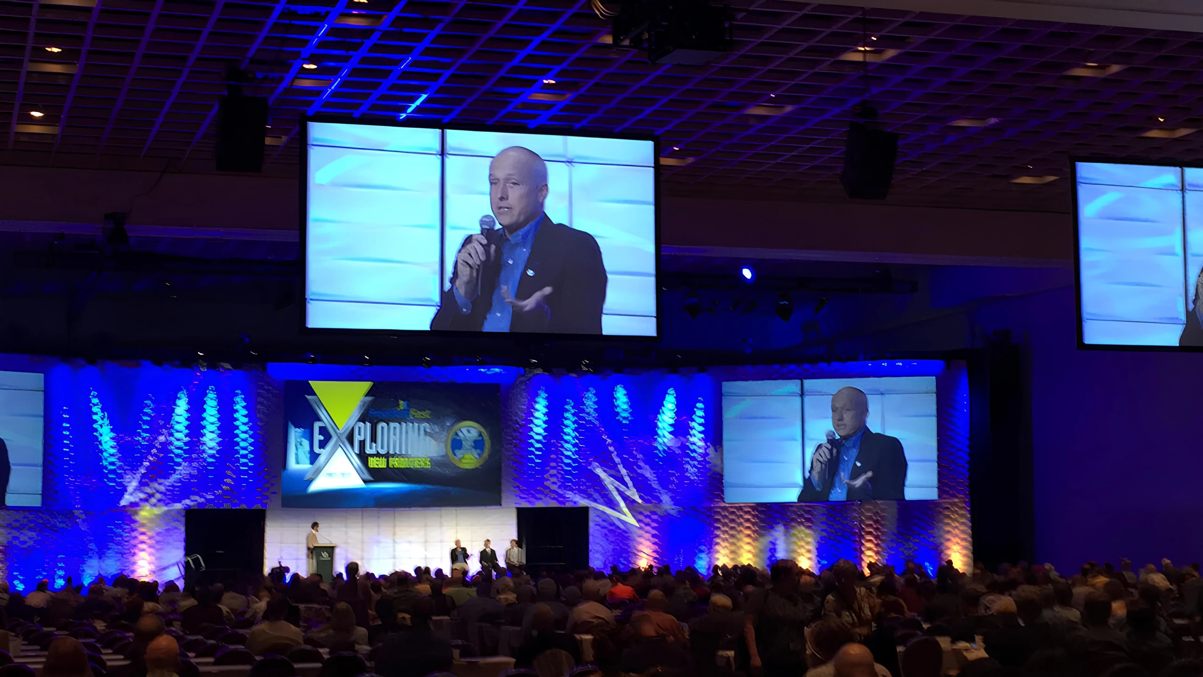 Mike Cobb speaking on stage to a full conference hall
